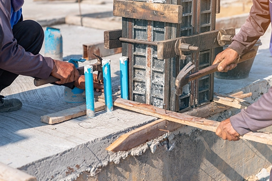 Crew assembling wooden concrete forms for residential foundation footing