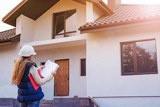 General contractor reviewing blueprints with client at a construction site