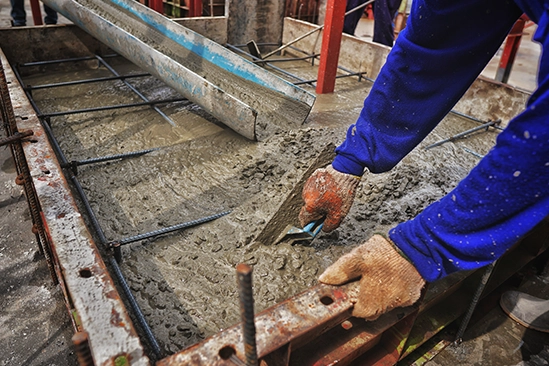 Poured concrete slab curing inside neatly aligned forming boards at jobsite